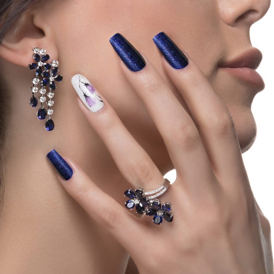 woman-with-nail-art-promoting-design-luxury-earrings-ring